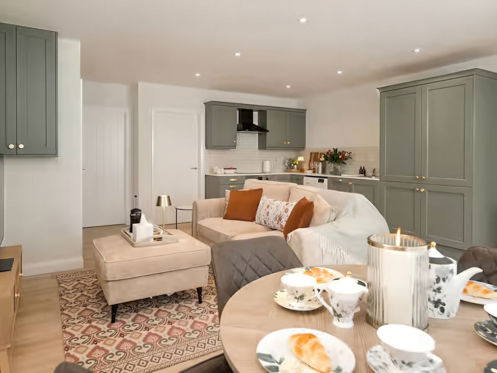A living room with a sofa and dining table at Long Meadow Apartment in Portglenone
