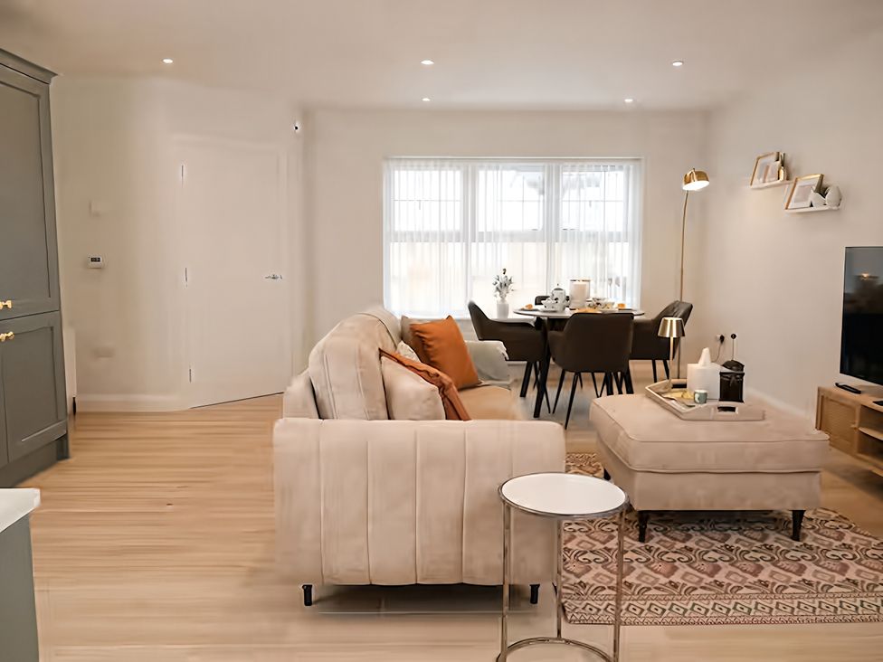 A living room with a sofa and dining area at Long Meadow Apartment in Portglenone