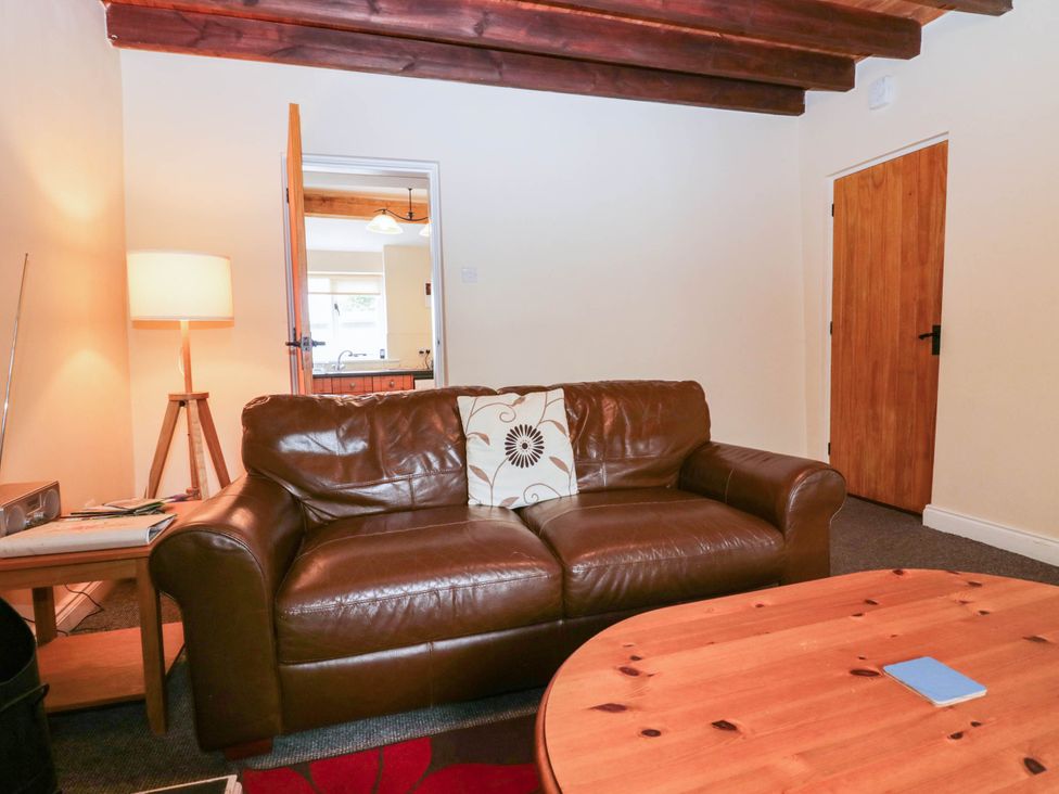 A living room with a sofa and lamp at Holly in Cleator