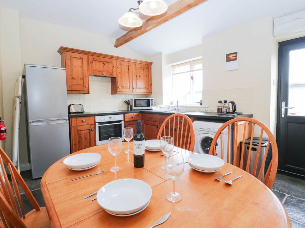 A kitchen with wooden cabinets and appliances at Holly in Cleator