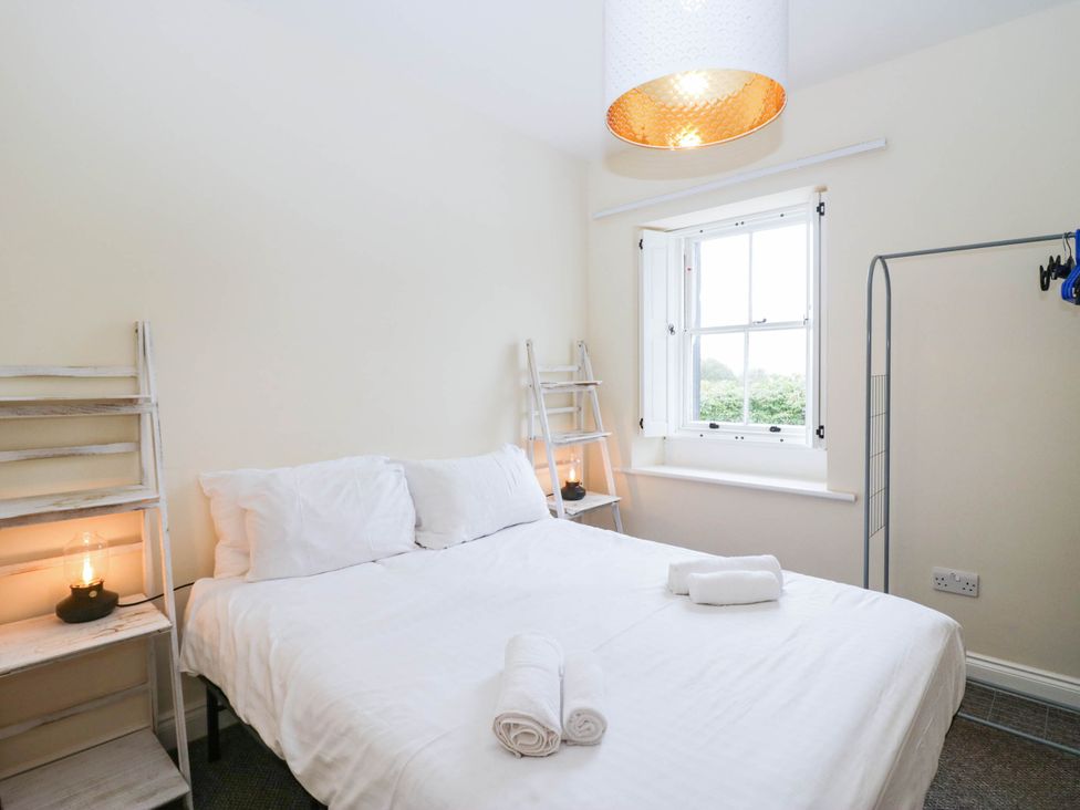 A bedroom with a bed and shelves at Holly in Cleator
