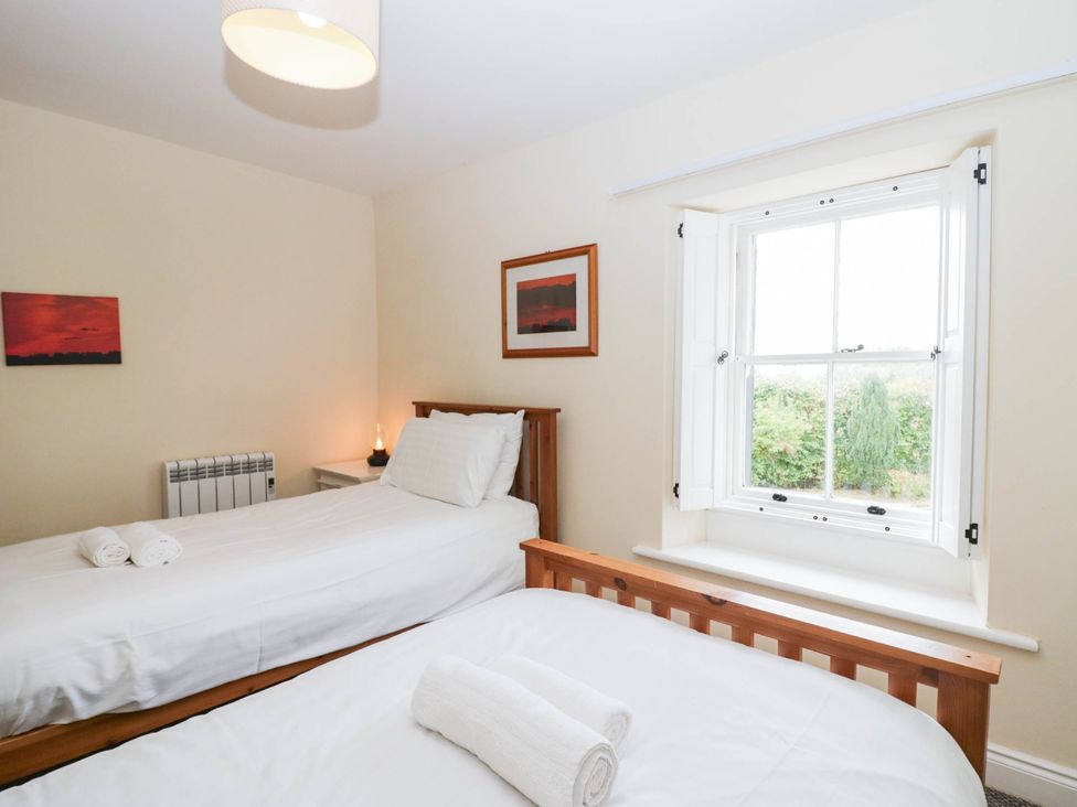 A bedroom with two beds and a window at Holly in Cleator