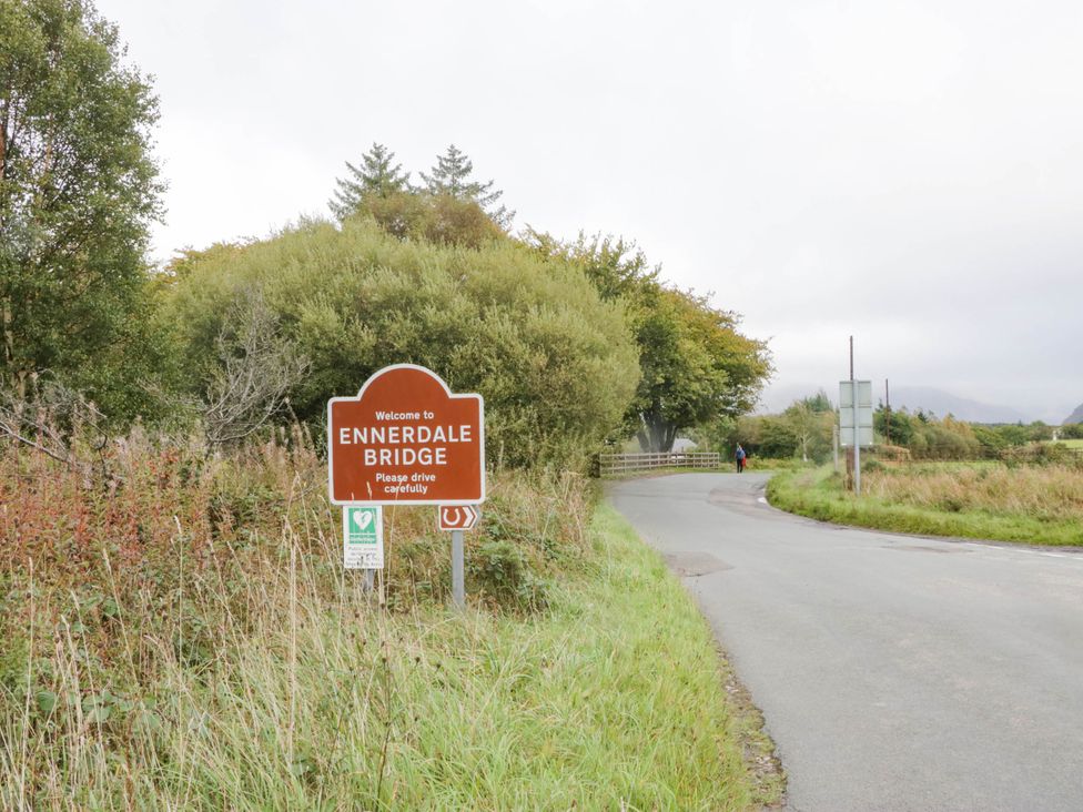 A welcome sign for Ennerdale Bridge near a road