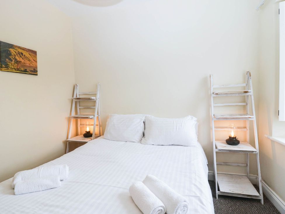 A bedroom with a bed and decorative shelves at Holly in Cleator