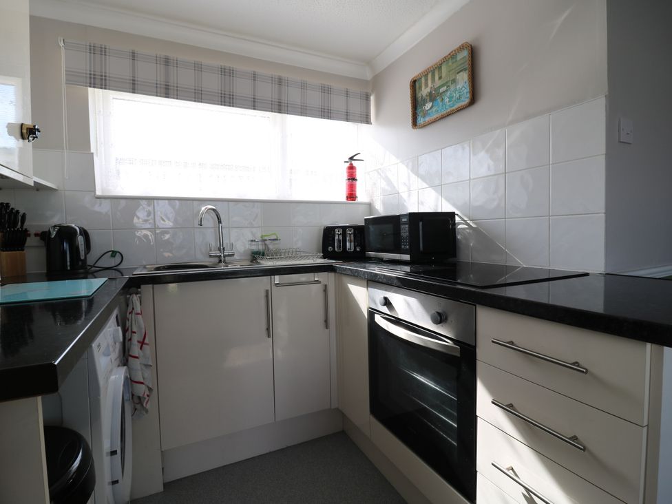 A kitchen with appliances and countertop at 110 Bay View in New Romney