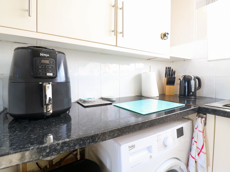 A kitchen with an air fryer and a washing machine at 110 Bay View in New Romney
