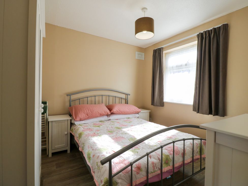 A bedroom with a bed and window at 110 Bay View in New Romney