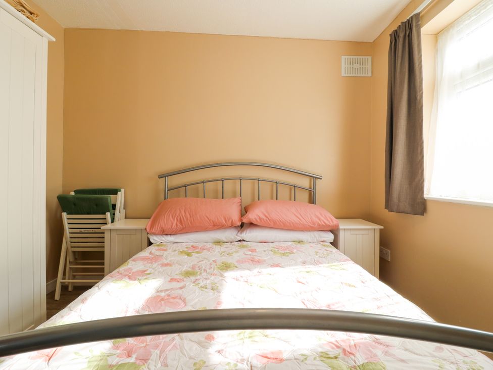 A bedroom with a bed and bedside table at 110 Bay View New Romney