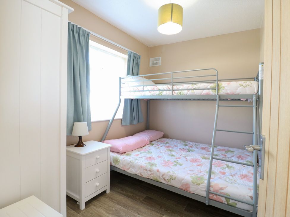 A bedroom with a bunk bed and nightstand at 110 Bay View New Romney