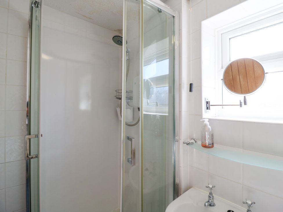 A bathroom with a shower and sink at 110 Bay View in New Romney