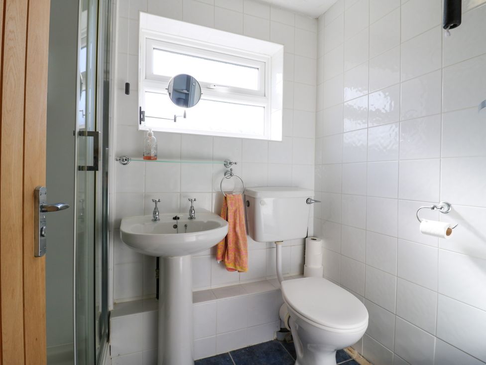 A bathroom with a sink, shower, and toilet at 110 Bay View in New Romney