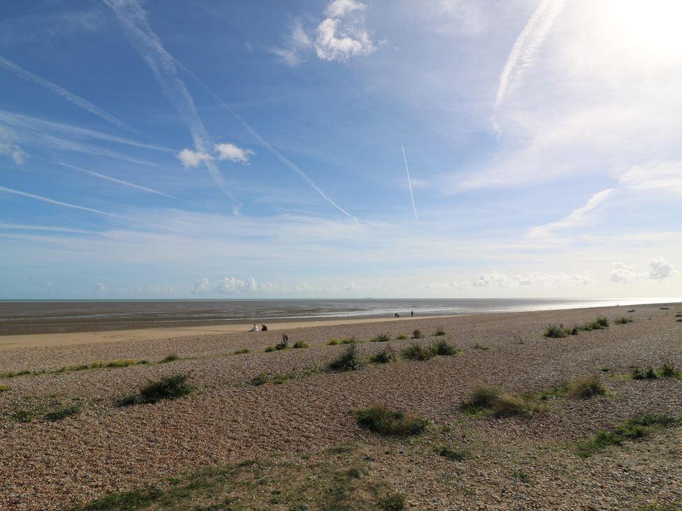 A beach with sand and water at 110 Bay View in New Romney
