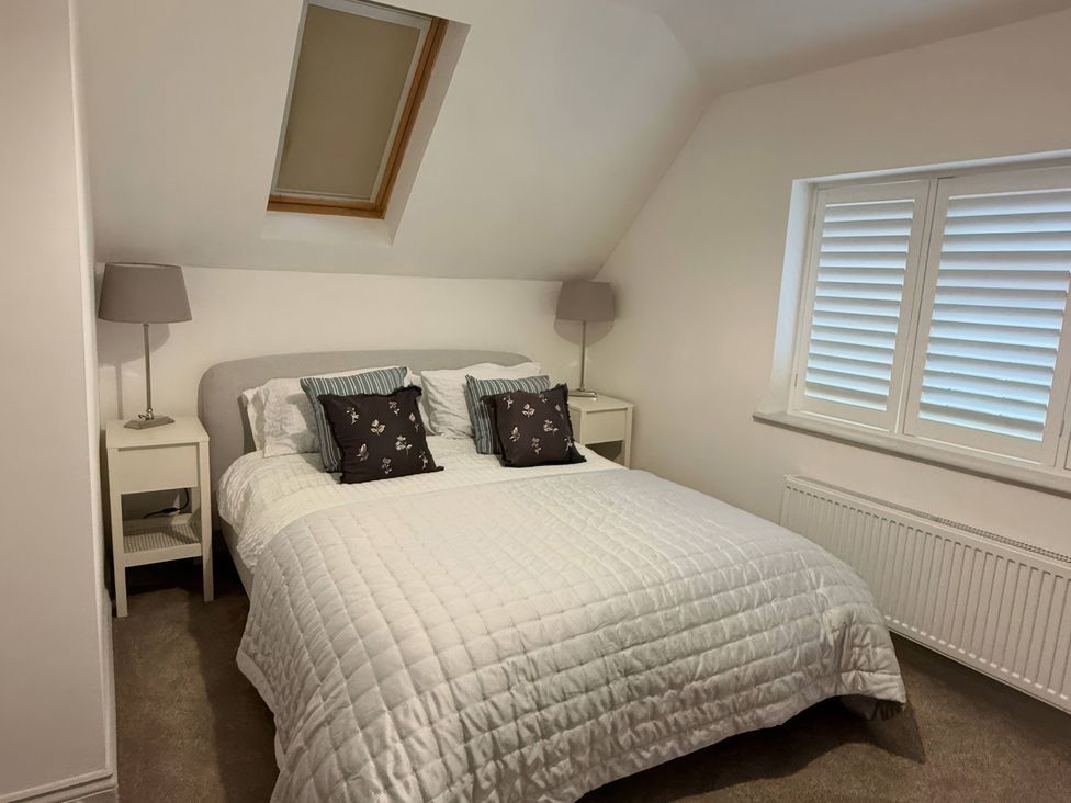 A bedroom with a bed and nightstands at Ridings Annex in Tonbridge