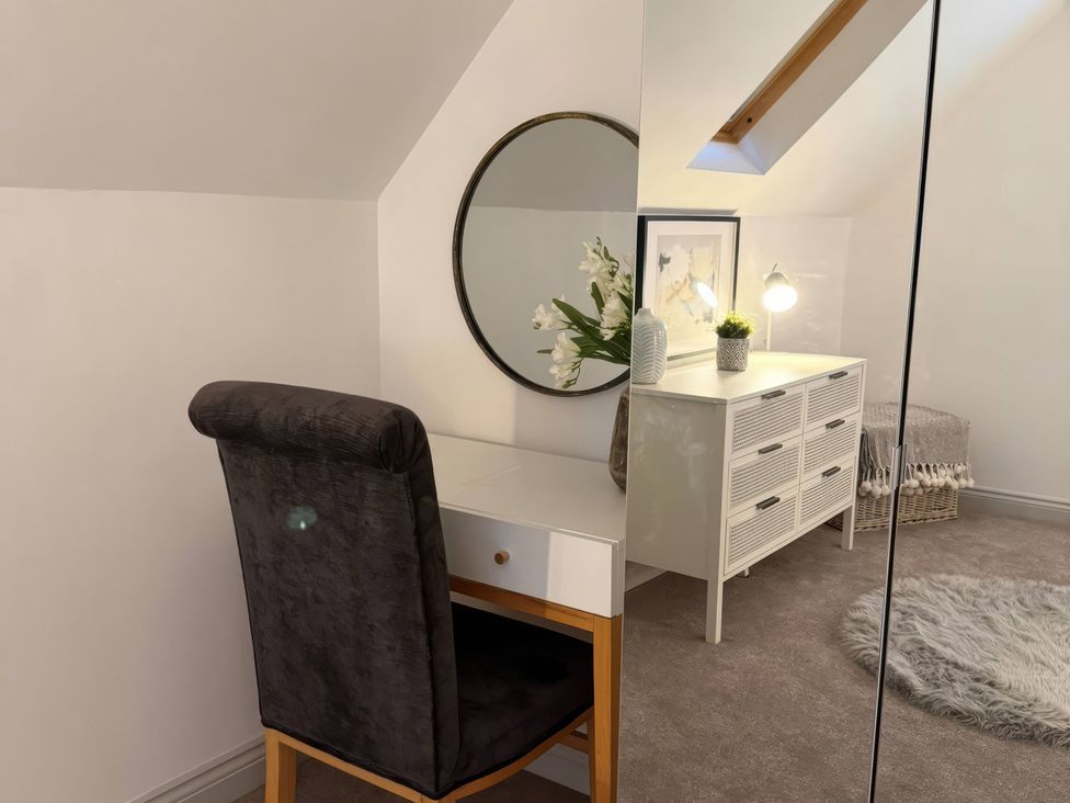 A home office with a desk, chair, and mirror at Ridings Annex in Tonbridge