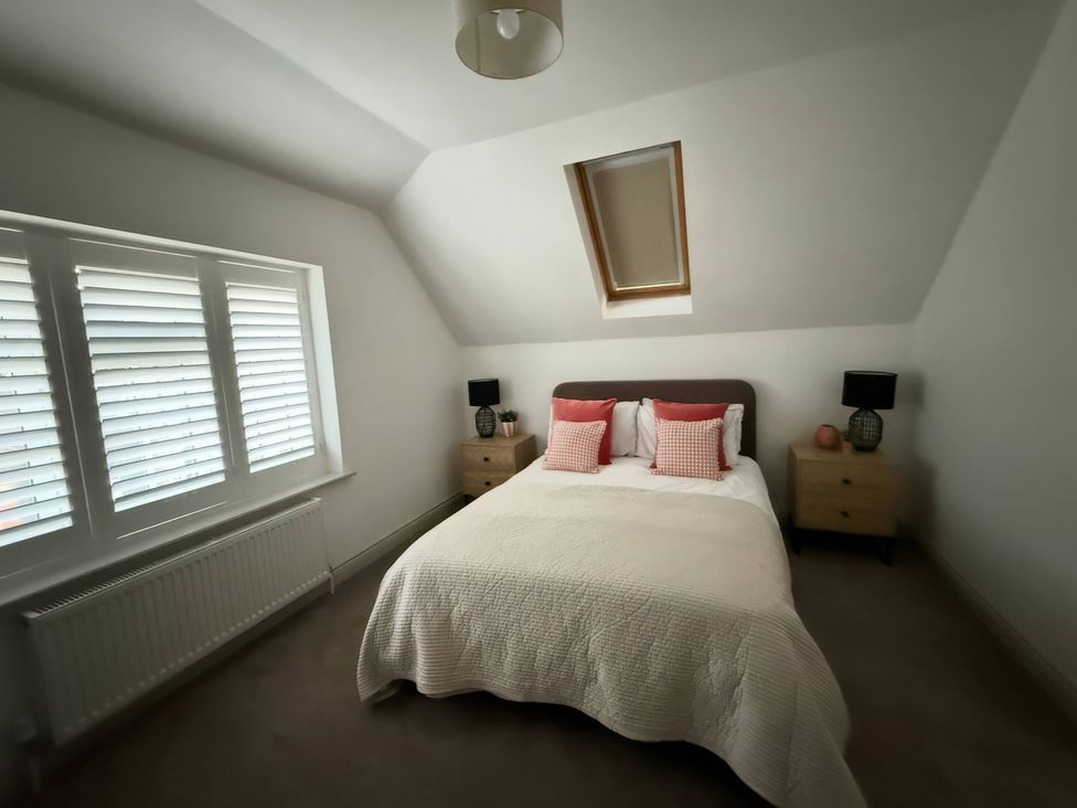 A bedroom with a bed and nightstands at Ridings Annex in Tonbridge