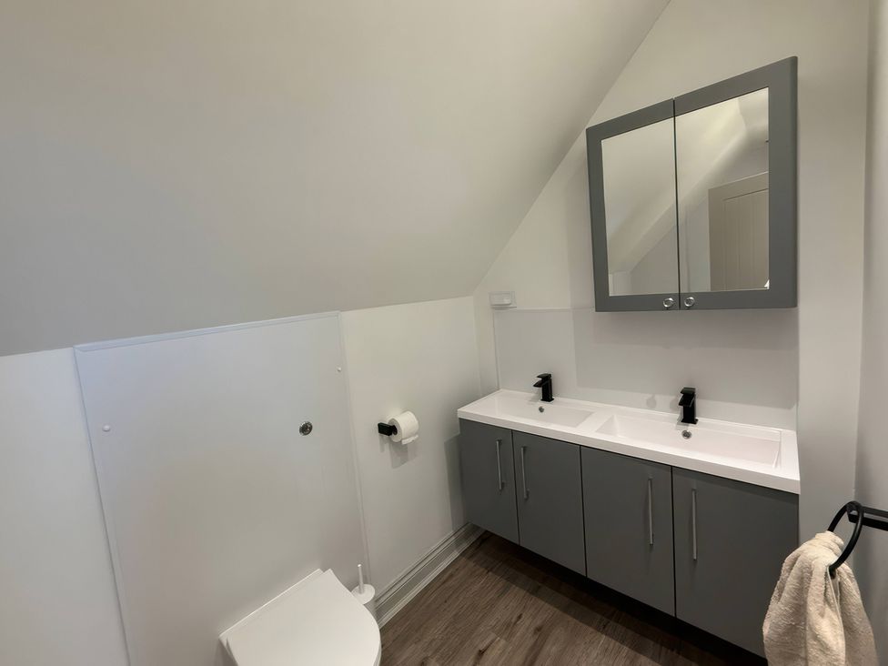 A bathroom with a toilet and double sink at Ridings Annex in Tonbridge