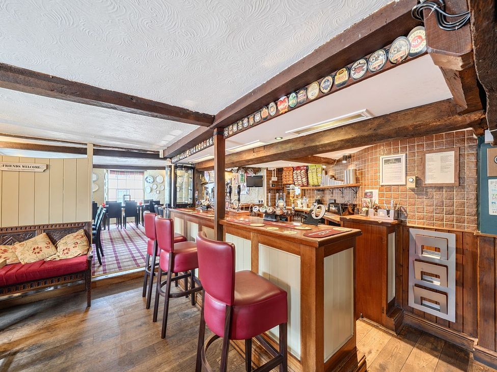 A bar area with stools and tables at The Half Boar in Bishop's Castle