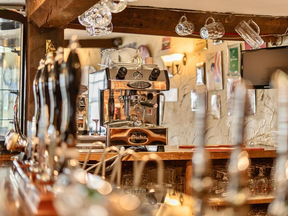 A bar with beer taps and a coffee machine at The Half Boar in Bishop's Castle