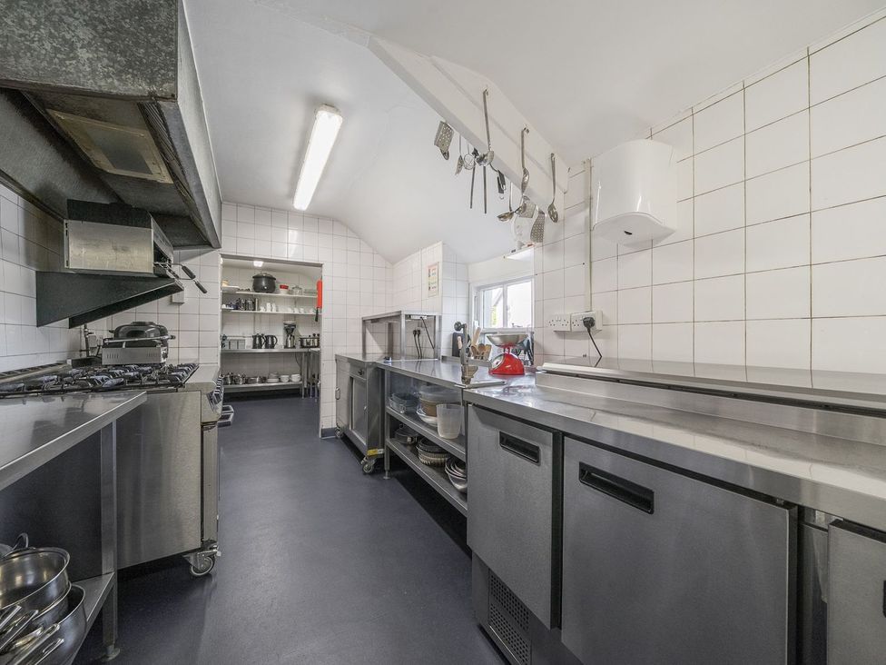 A kitchen with countertops and shelving at The Half Boar in Bishop's Castle