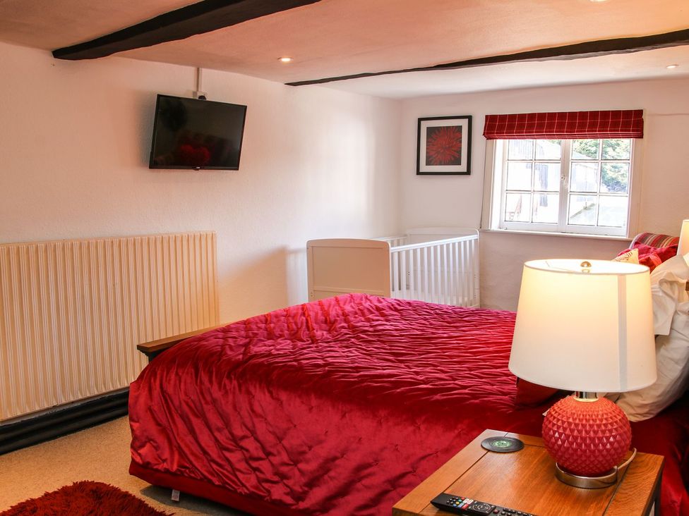 A bedroom with a bed and television at The Half Boar in Bishop's Castle