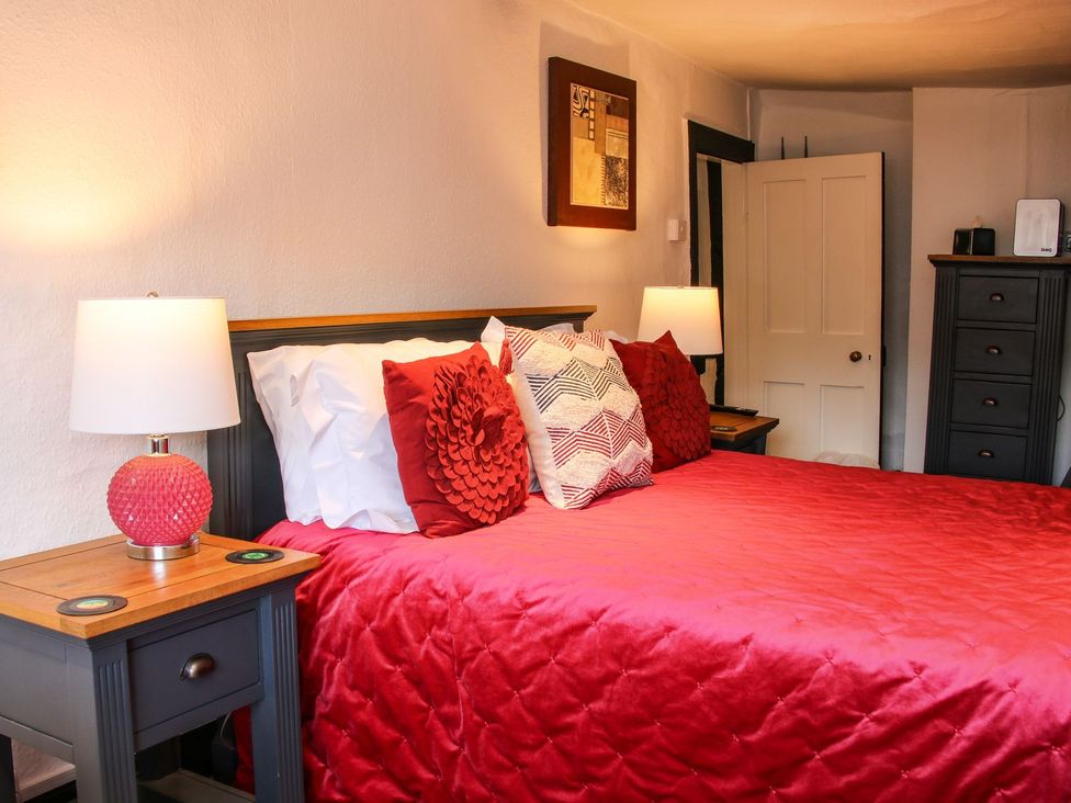 A bedroom with a bed and nightstand at The Half Boar in Bishop's Castle