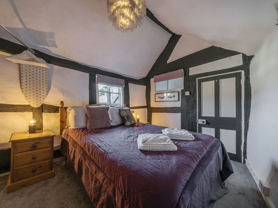 A bedroom with a bed and bedside table at The Half Boar in Bishop's Castle
