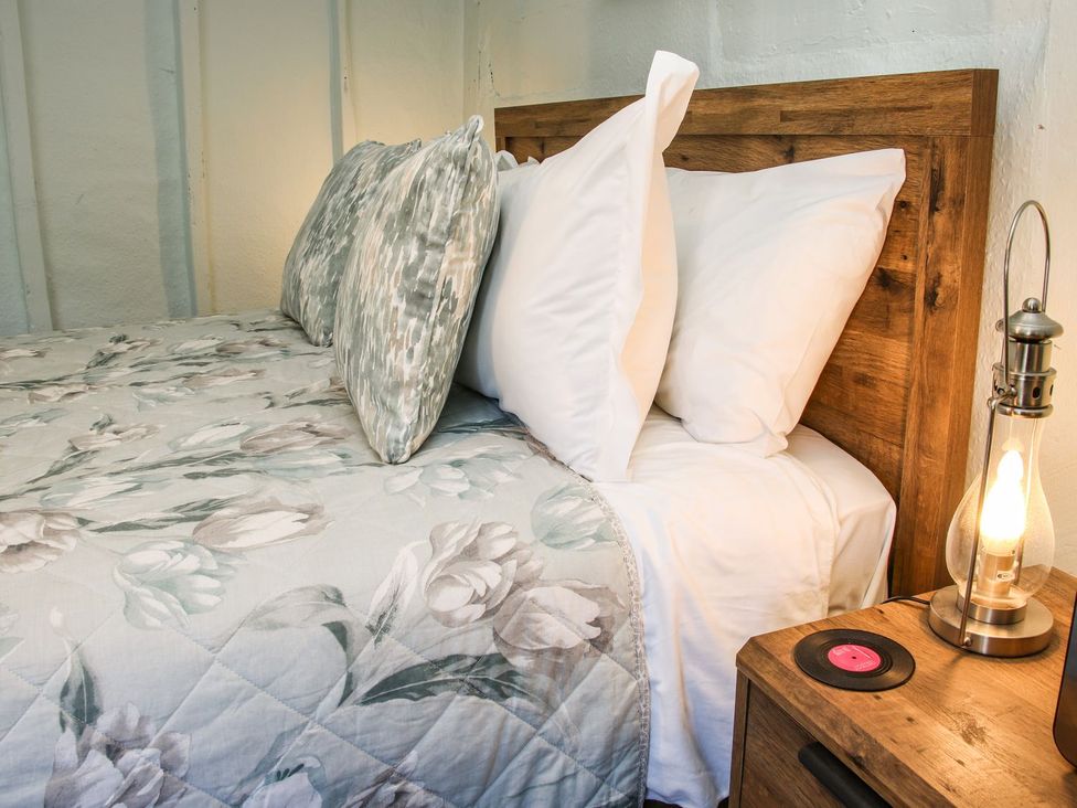 A bedroom with a bed and side table at The Half Boar in Bishop's Castle