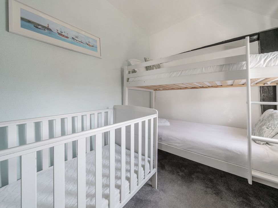 A bedroom with a bunk bed and crib at The Half Boar in Bishop's Castle