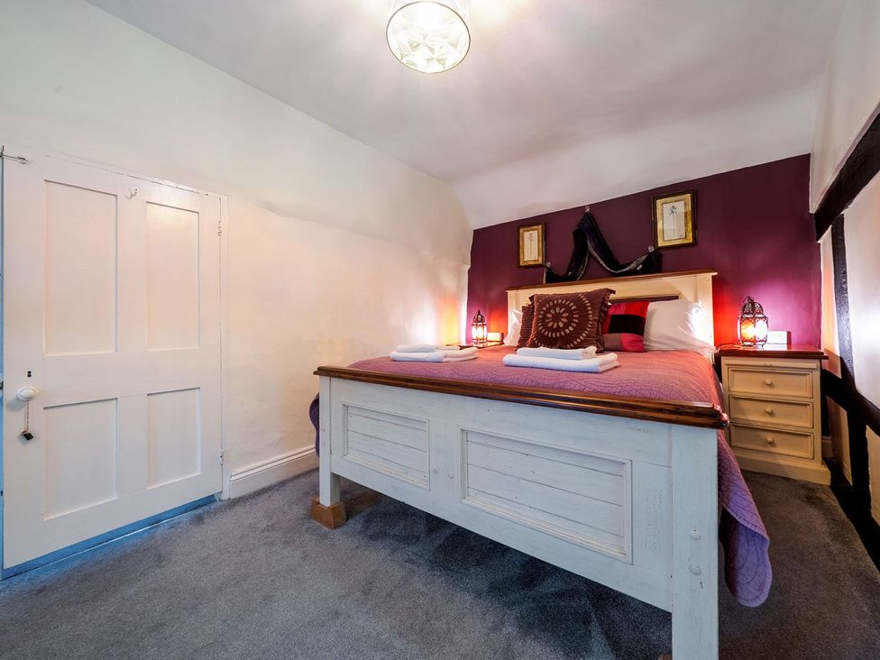 A bedroom with a bed and bedside table at The Half Boar in Bishop's Castle