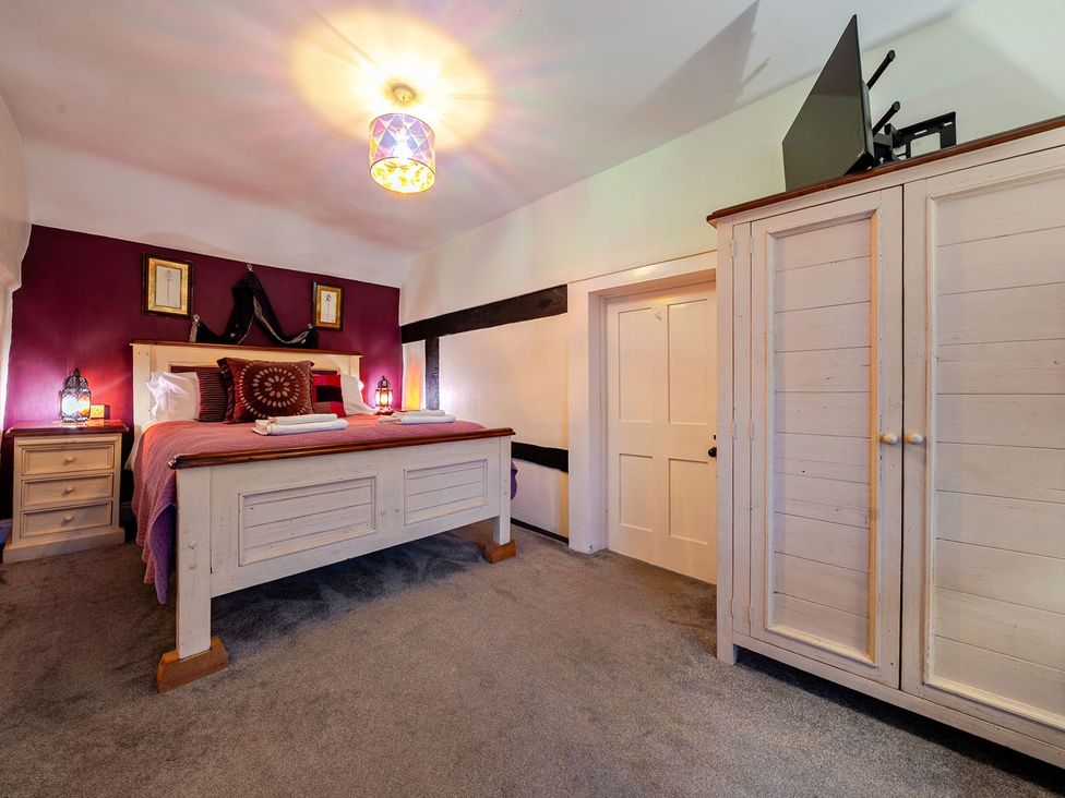 A bedroom with a bed and wardrobe at The Half Boar in Bishop's Castle