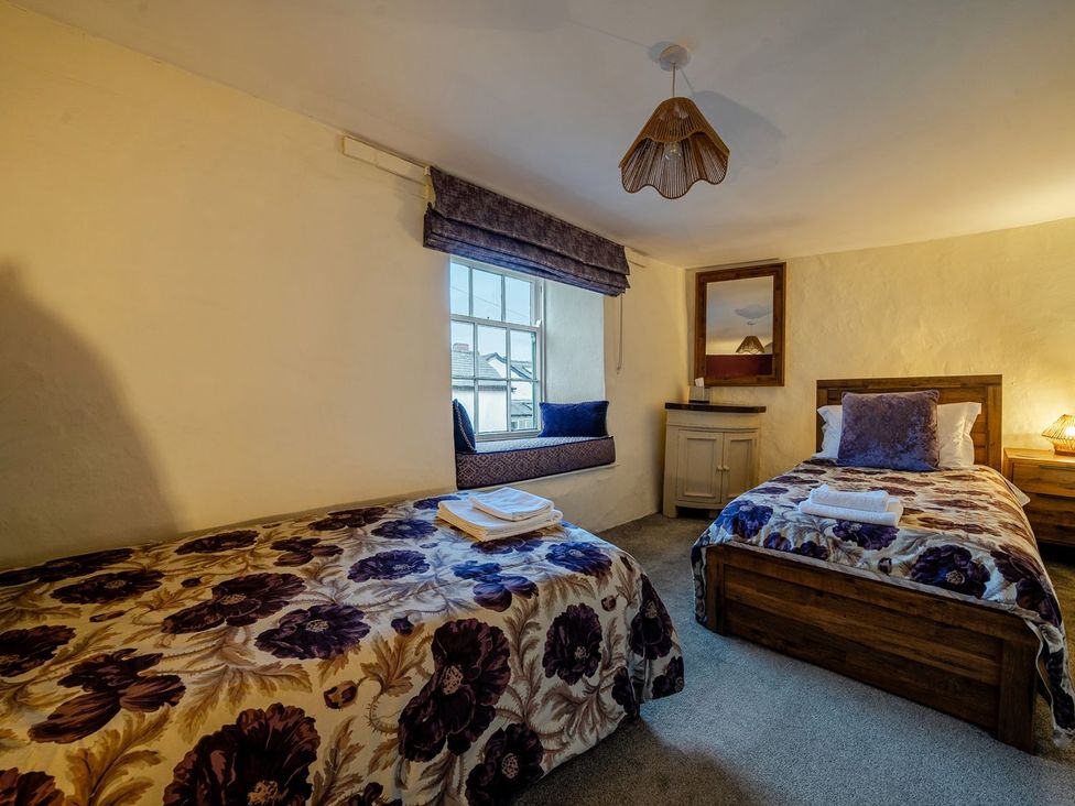 A bedroom with two beds and a window seating area at The Half Boar in Bishop's Castle