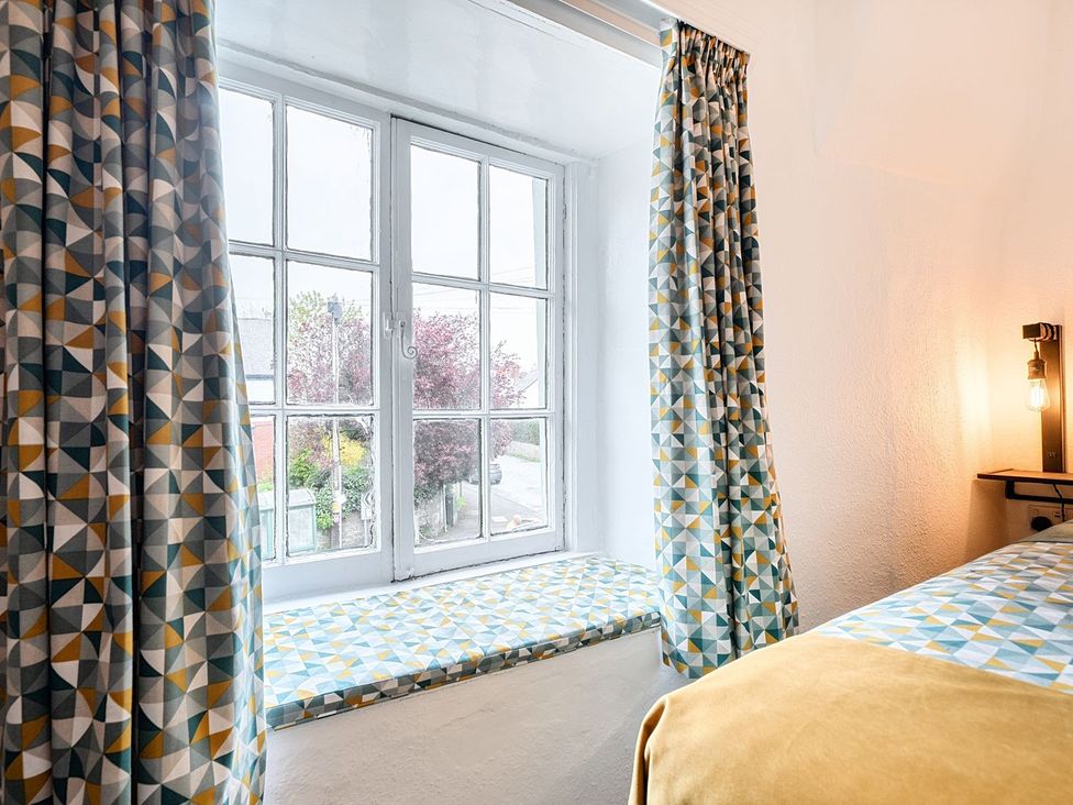 A bedroom with a window and patterned curtains at The Half Boar in Bishop's Castle