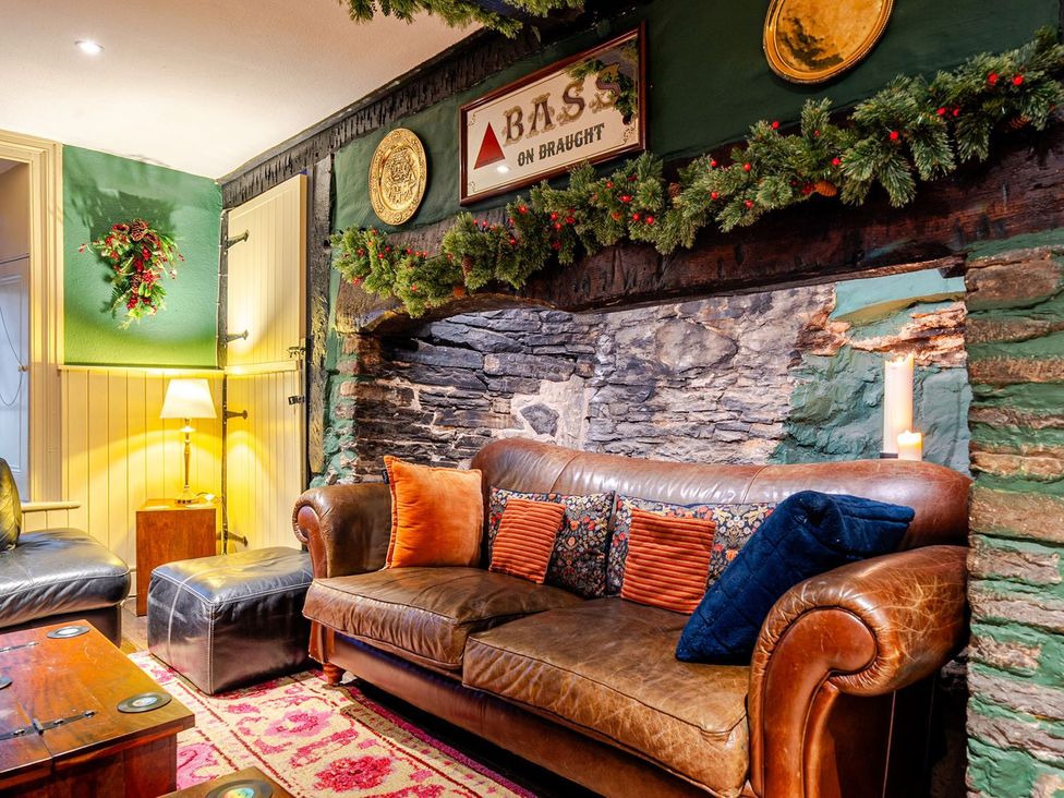 A living room with a leather sofa and decorative items at The Half Boar in Bishop's Castle