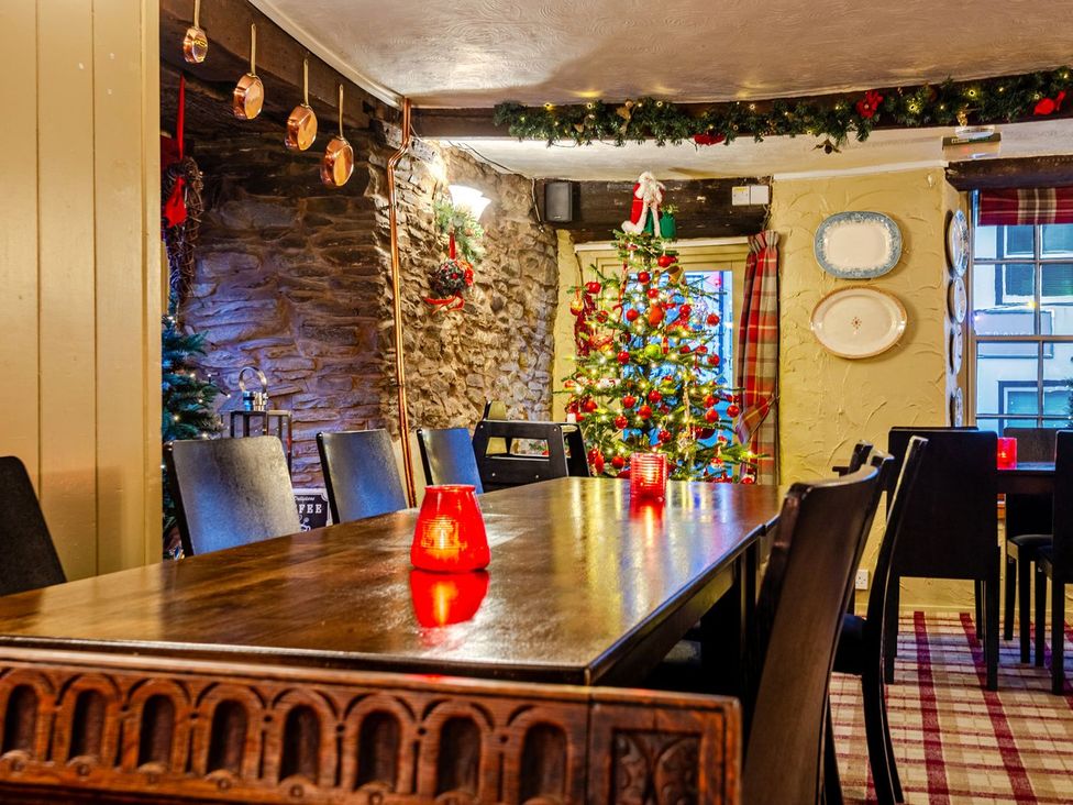 A dining room with a Christmas tree and a large table at The Half Boar in Bishop's Castle