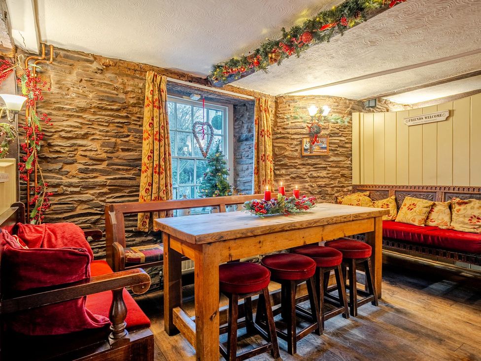 A dining room with a wooden table and stools at The Half Boar in Bishop's Castle