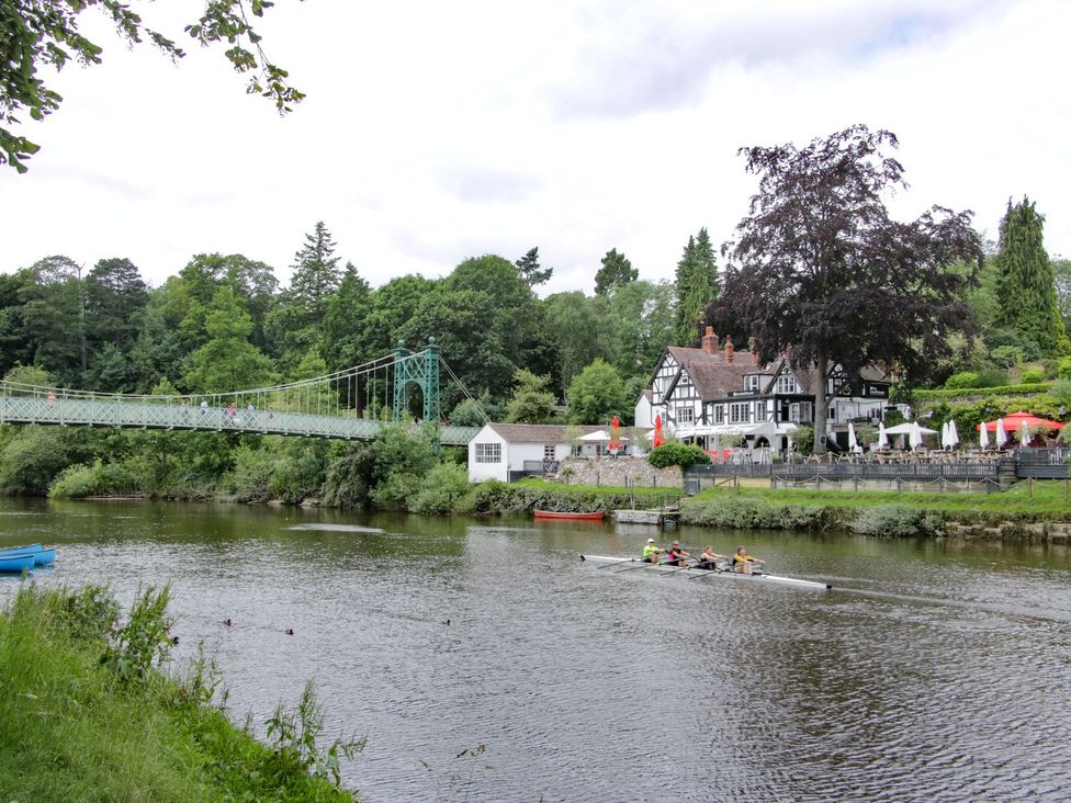 A river with a bridge and a house at The Half Boar in Bishop's Castle