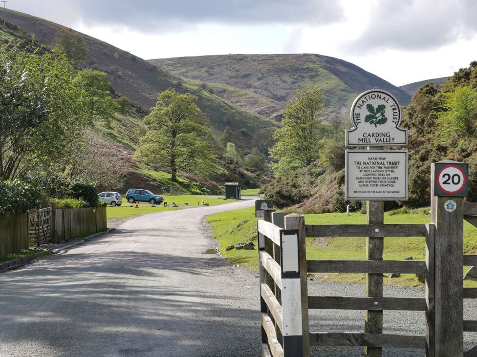 A view of Carding Mill Valley entrance with a sign at The Half Boar in Bishop's Castle