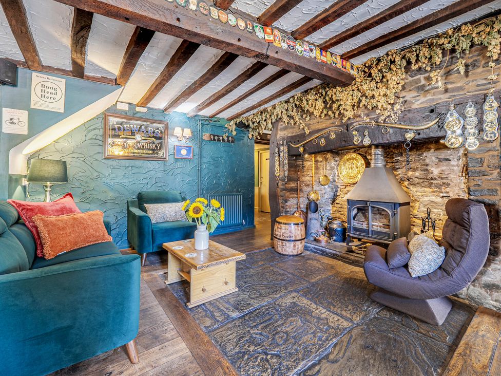 A living room with a fireplace and seating area at The Half Boar in Bishop's Castle