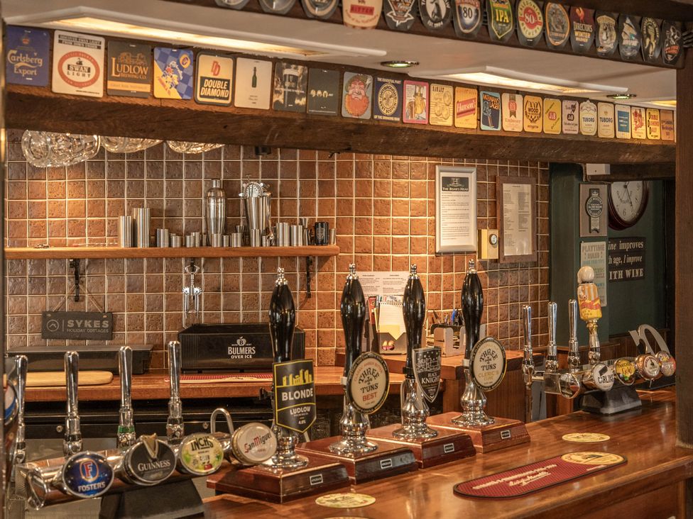 A bar with taps and drinks displayed at The Half Boar in Bishop's Castle
