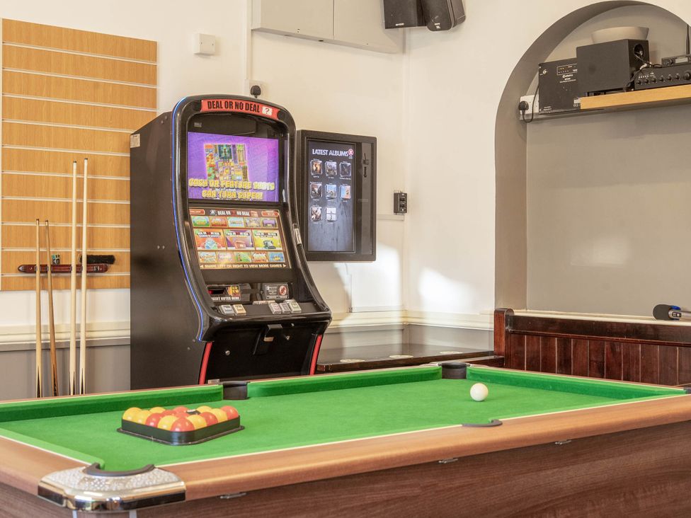 A games room with a pool table and slot machine at The Half Boar in Bishop's Castle