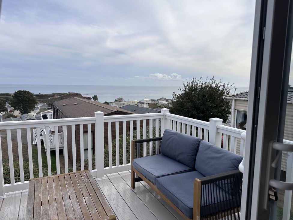 A patio with a sofa and table overlooking the ocean at Club Sahara Sandy Bay, Exmouth