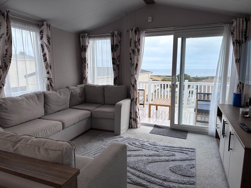 A living room with a sofa and sliding door at Club Sahara Sandy Bay, Exmouth