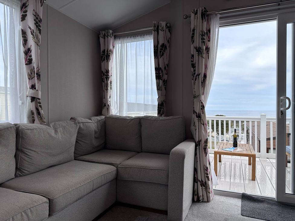 A living room with a sofa and view to a deck at Club Sahara, Sandy Bay, Exmouth