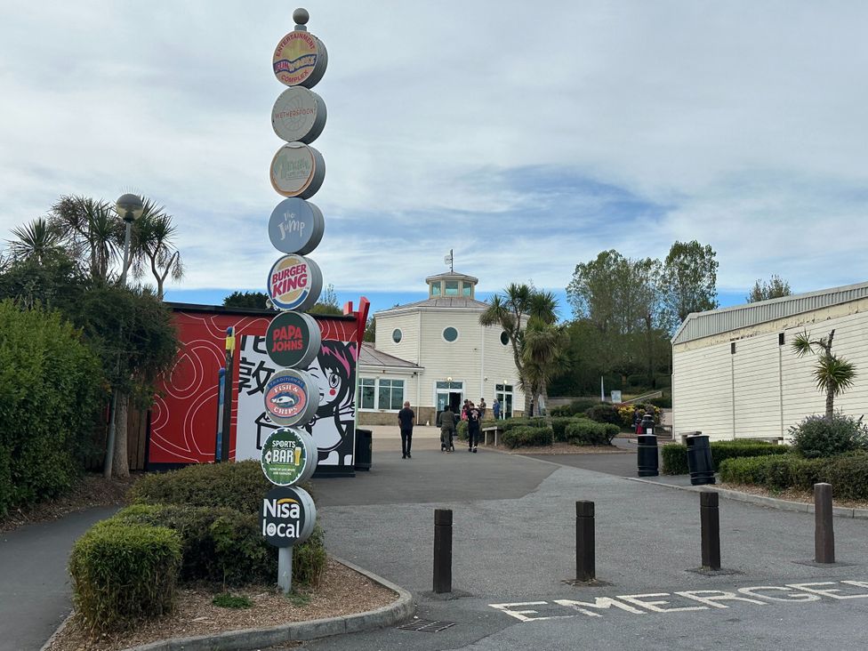 A building with a signpost and people outside at Club Sahara in Sandy Bay, Exmouth