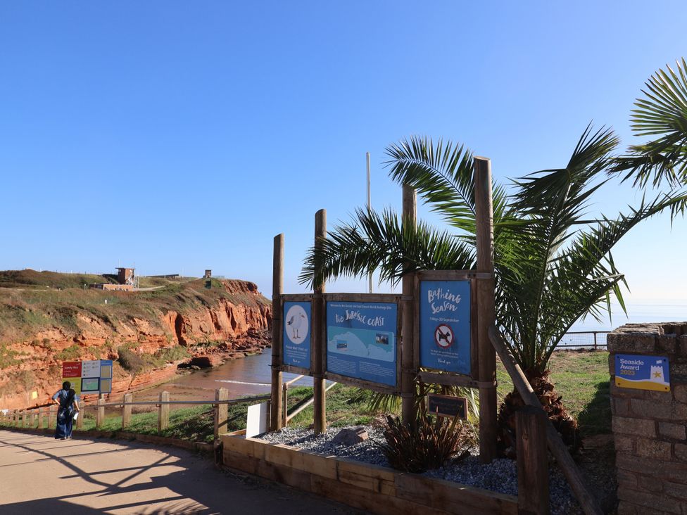 An outdoor sign near a beach with a palm tree at Club Sahara Sandy Bay, Exmouth