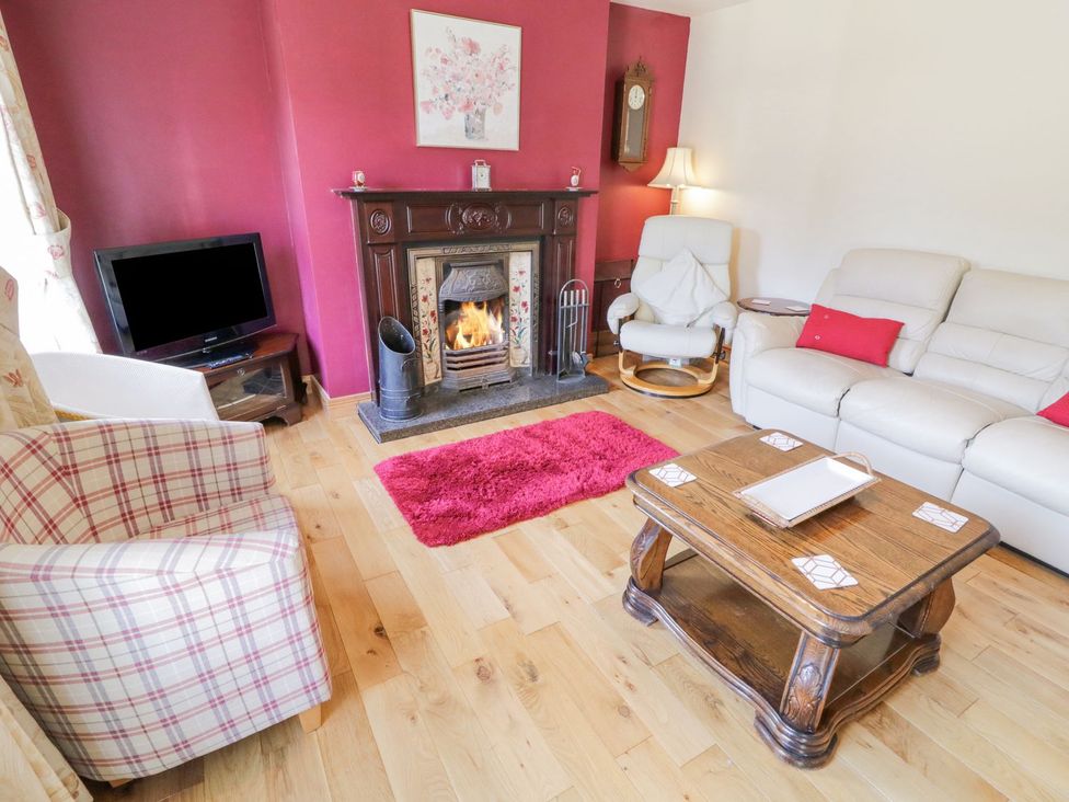 A living room with a fireplace and sofa at Craiglea Lodge in Coleraine