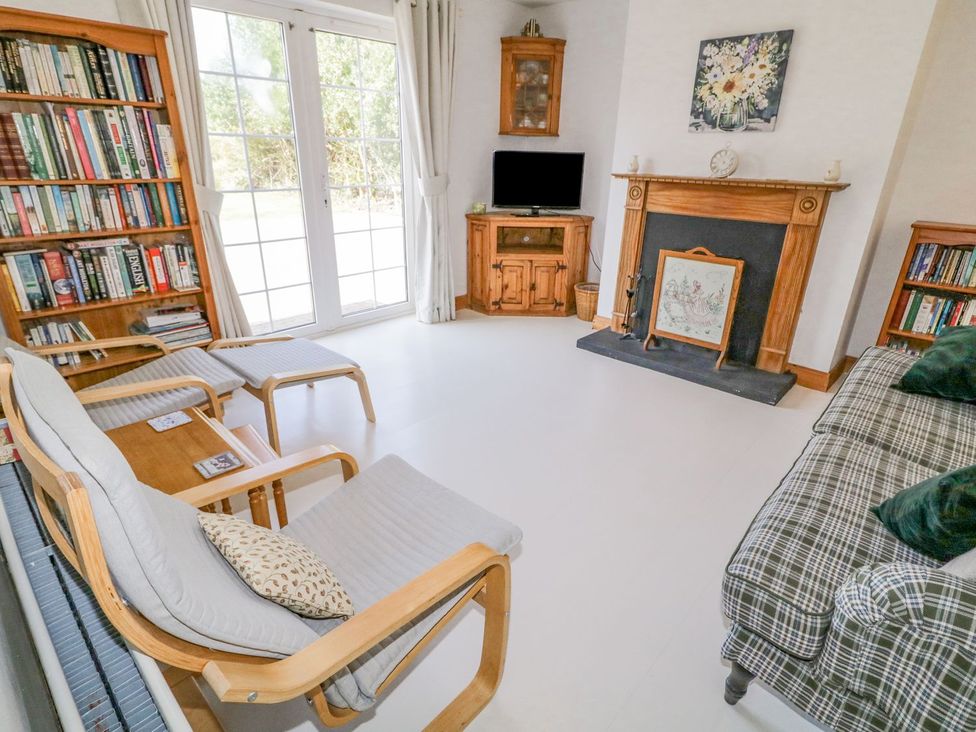 A living room with a bookshelf and sofa at Craiglea Lodge in Coleraine