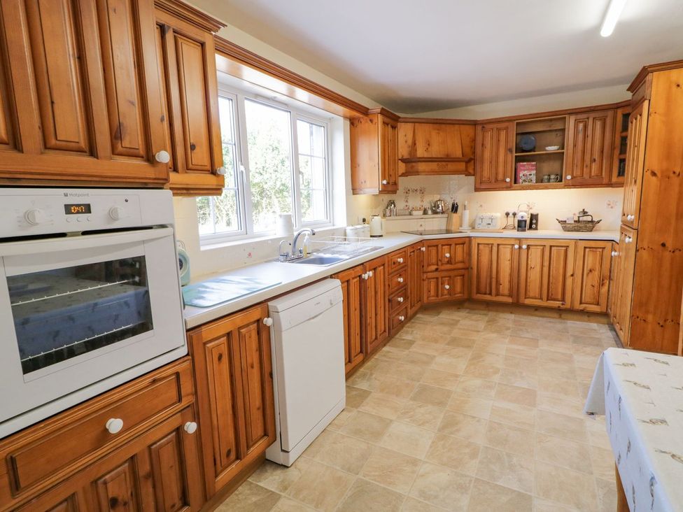 A kitchen with wooden cabinets and appliances at Craiglea Lodge in Coleraine
