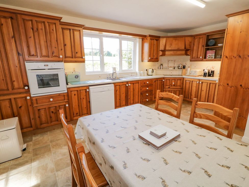 A kitchen with wooden cabinetry and a dining table at Craiglea Lodge in Coleraine