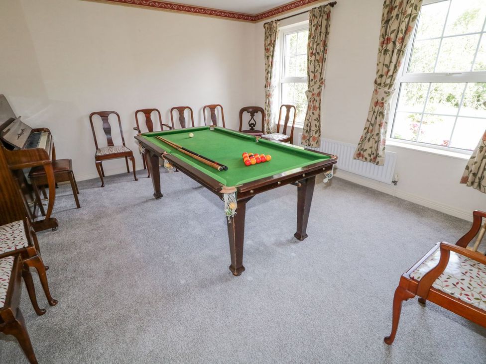 A snooker table with cue stick and chairs at Craiglea Lodge in Coleraine